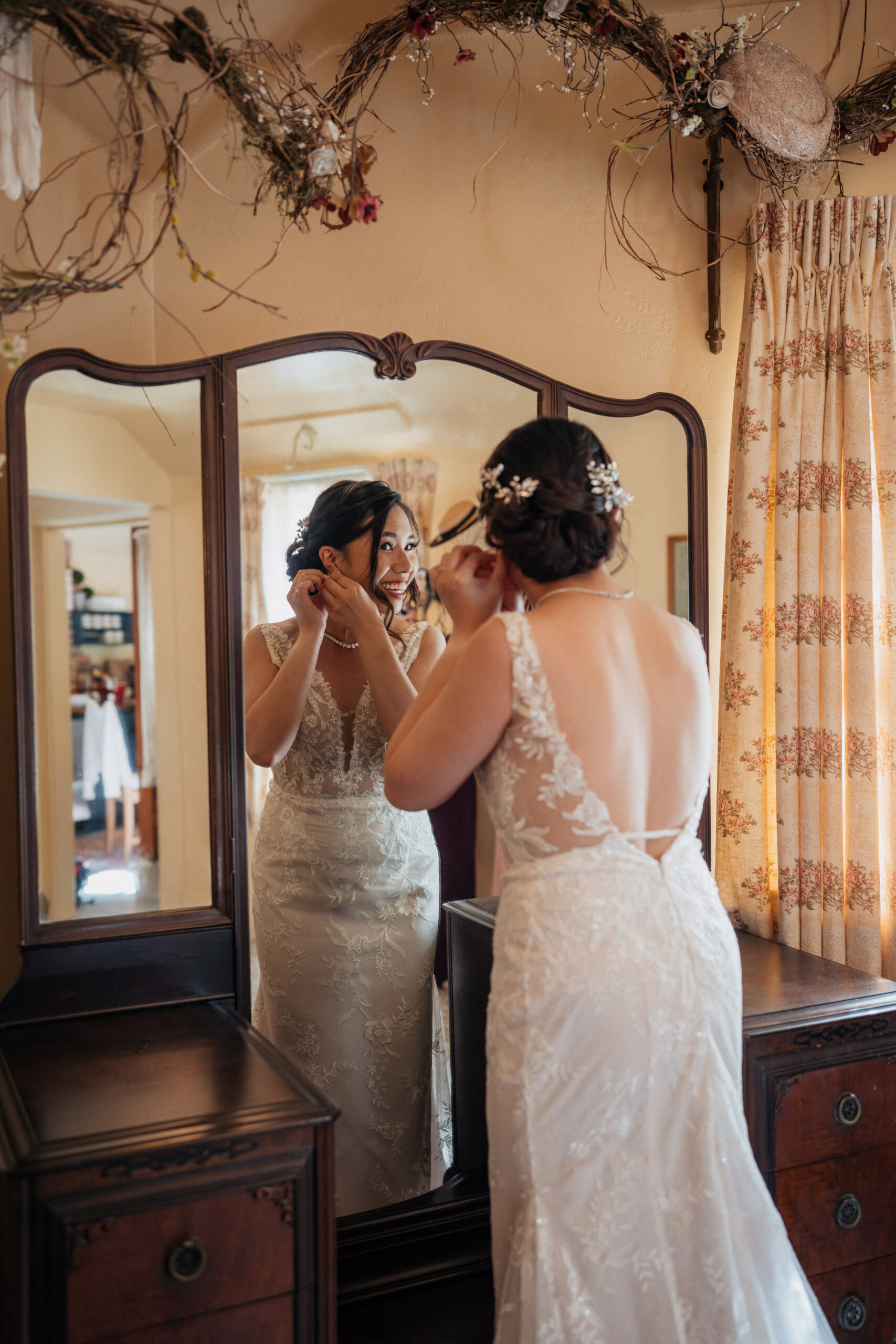 Bride putting on earrings in bridal cottage at the homestead in oak glen