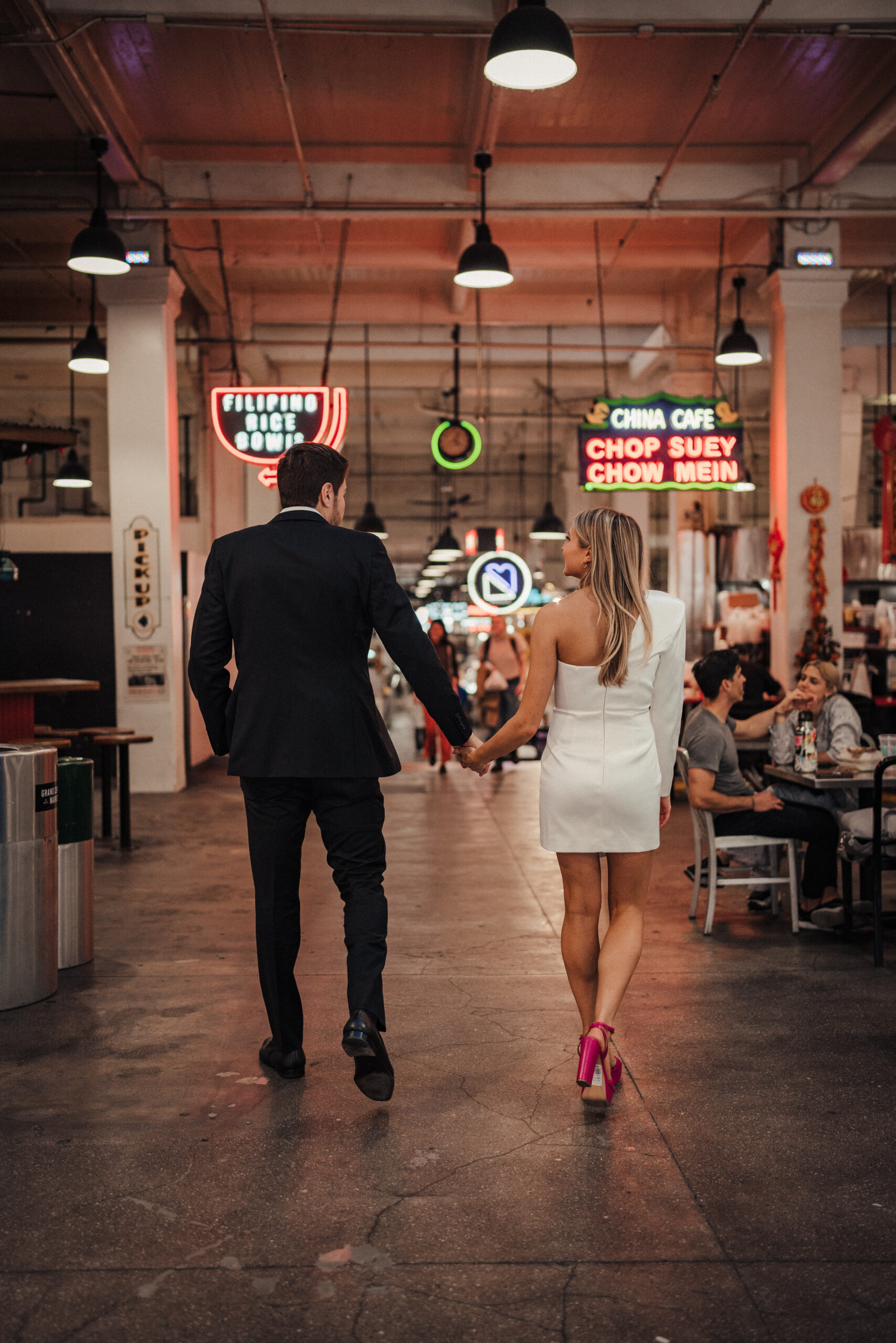 Engaged couple walks through Grand Central Market LA for engagement photos 