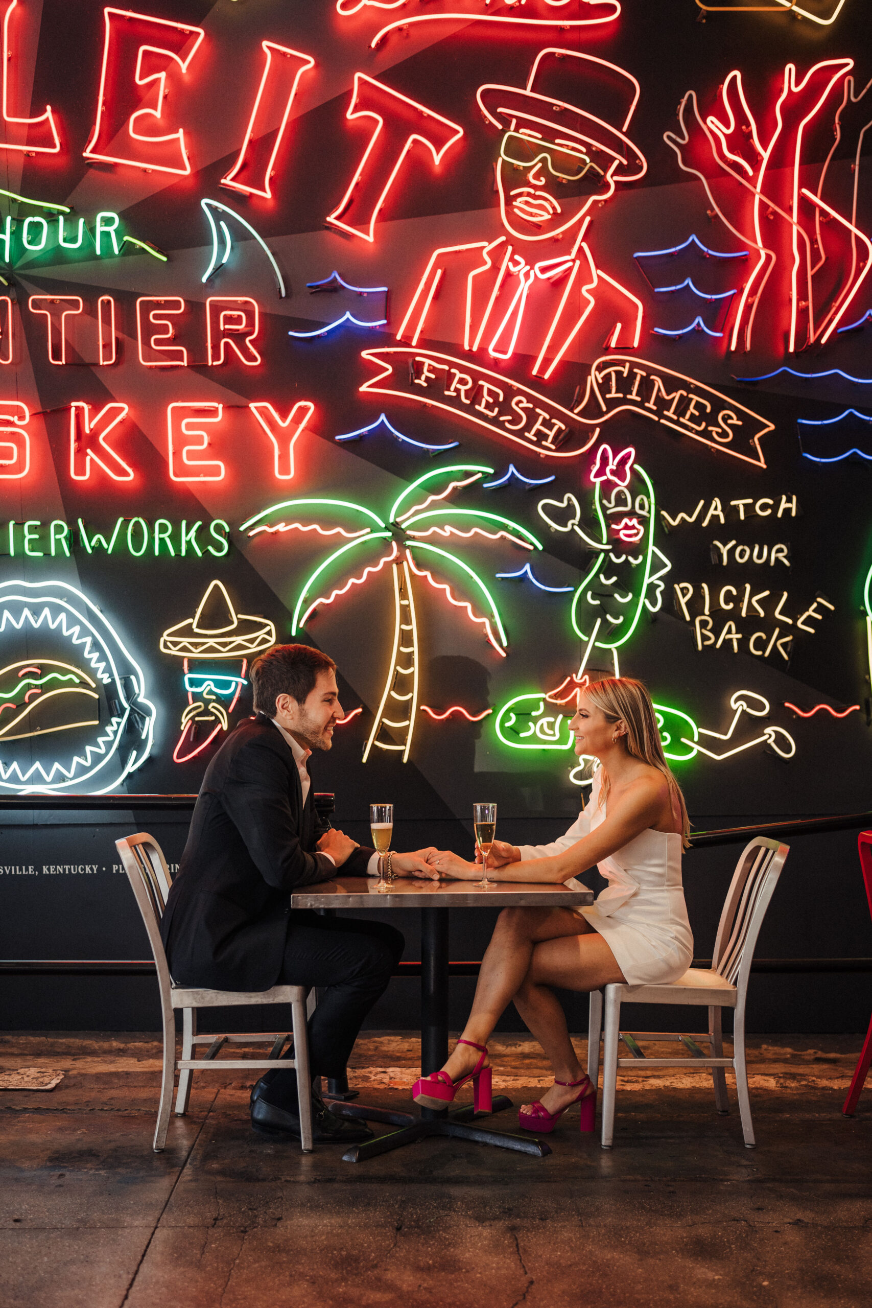 A couple drinks champagne together at Grand Central Market in Downtown Los Angeles for their engagement session. 