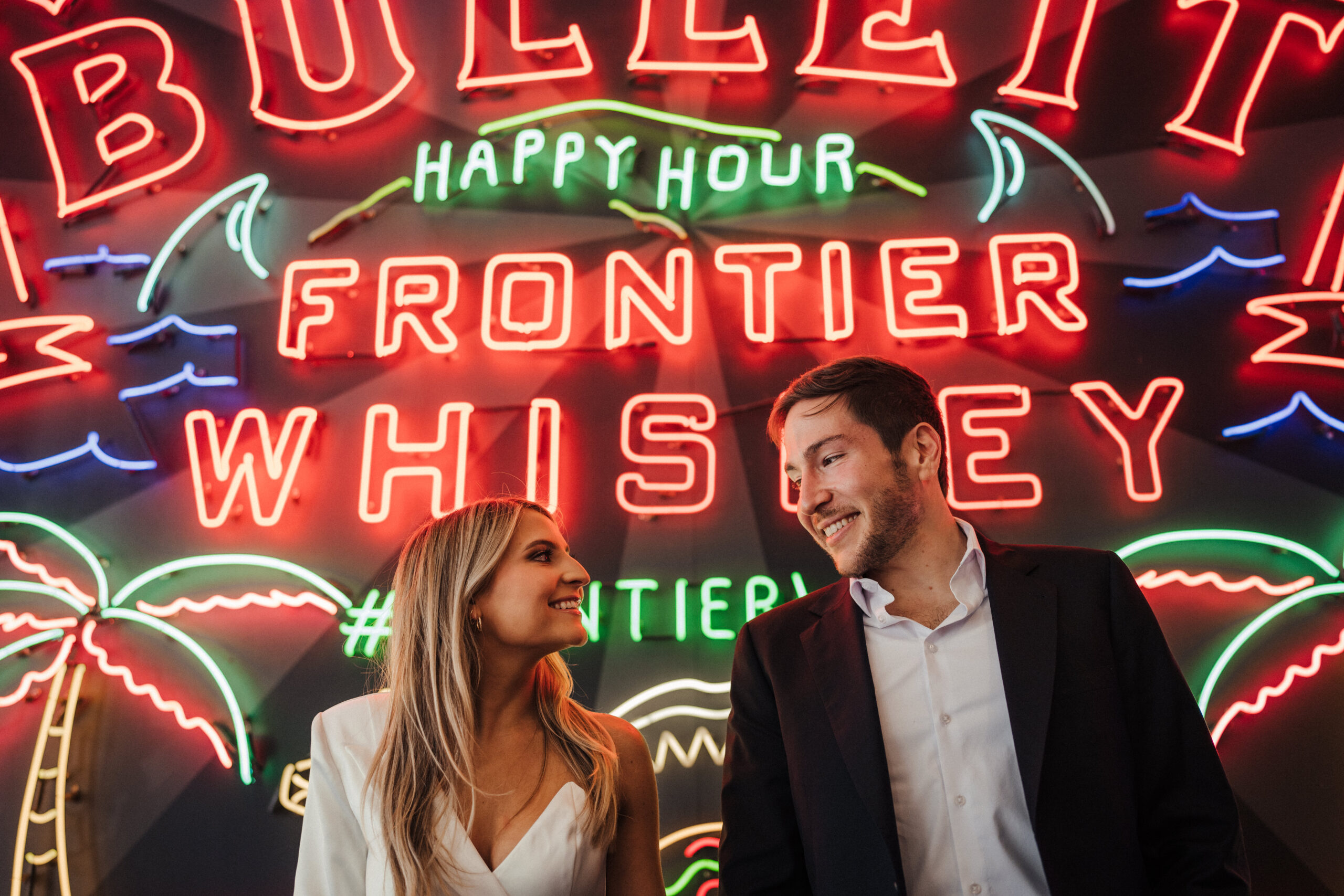 Engagement session at Grand Central Market in Los Angeles in front of the neon signs.