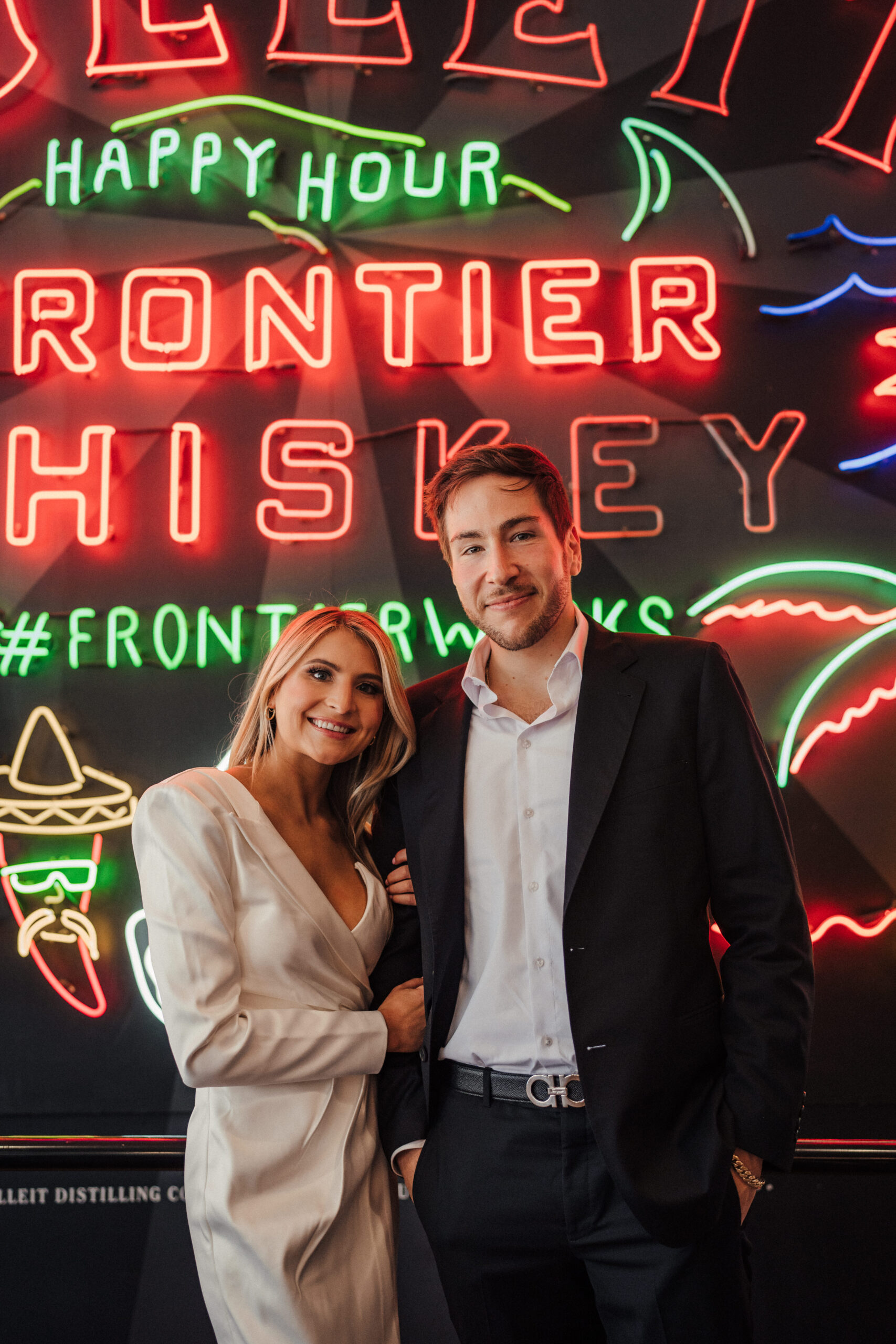Engagement session at Grand Central Market in Los Angeles in front of the neon signs.
