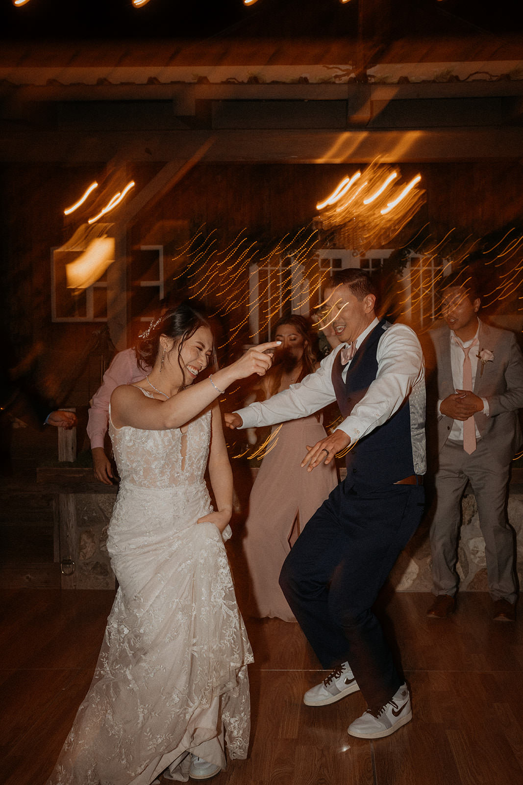 Bride and groom dancing at their reception under the lights of the homestead.