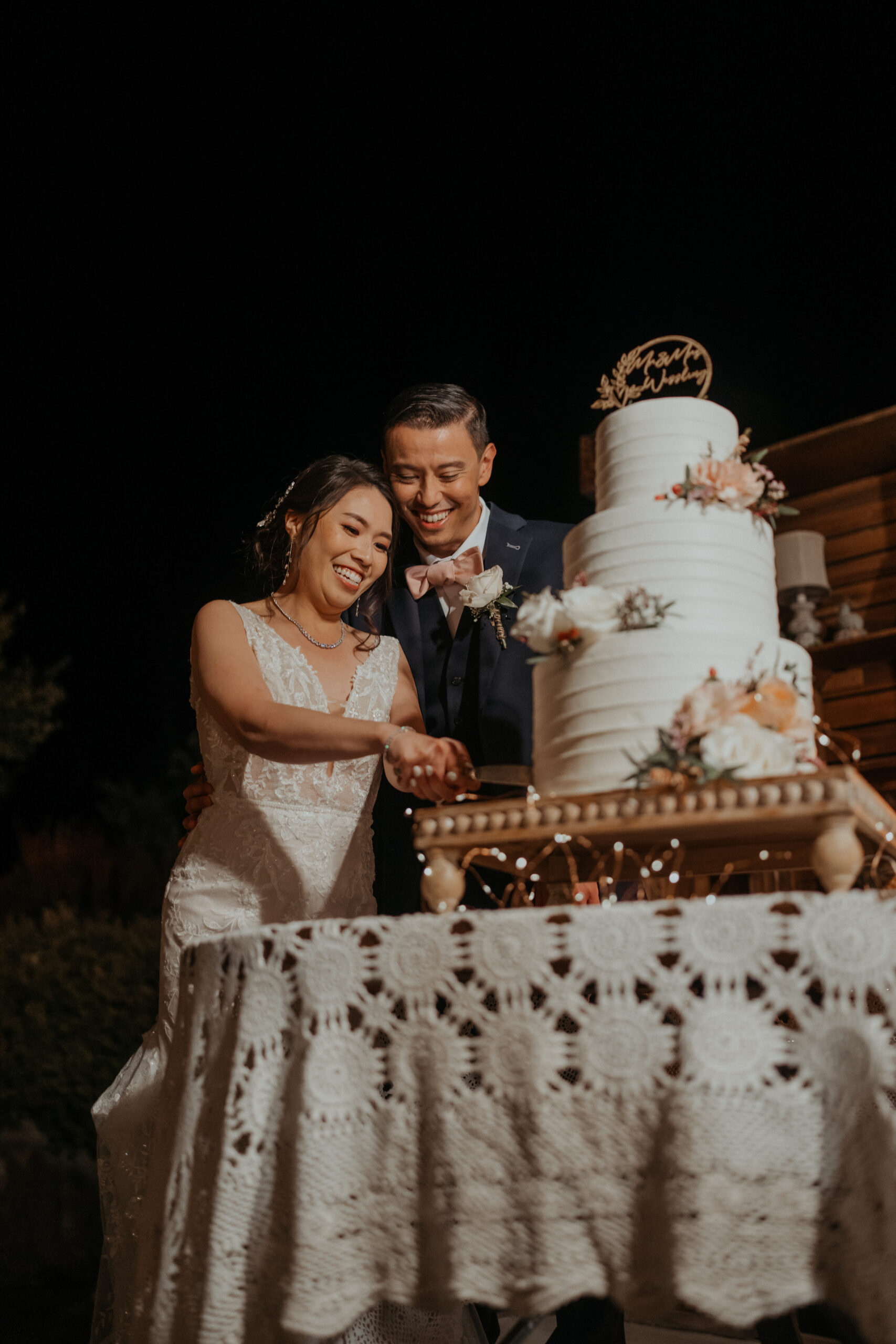 Bride and groom cutting wedding cake at the homestead in oak glen california.